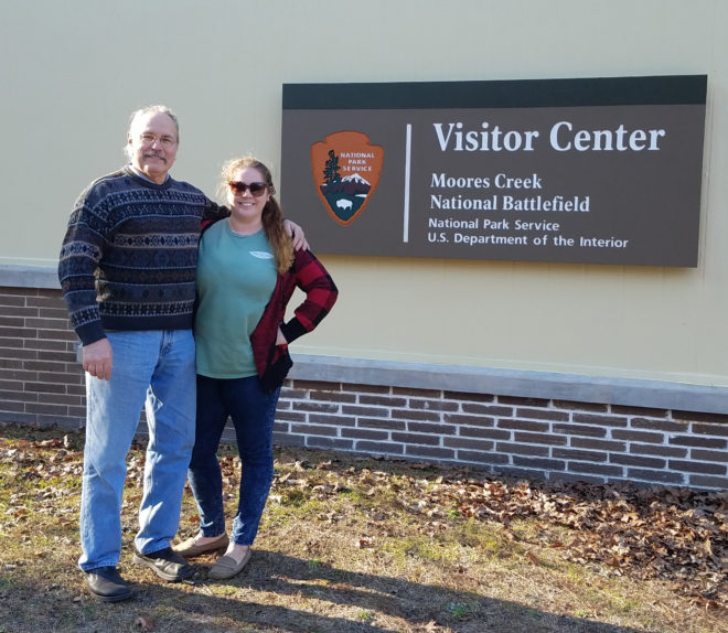 Visitors beside Moores Creek National Battlefield sign